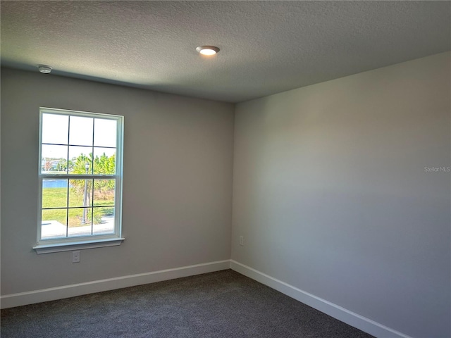 carpeted spare room featuring a textured ceiling