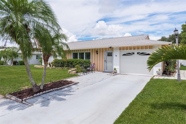 single story home featuring a garage and a front lawn