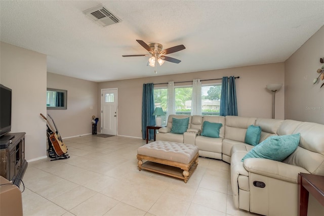 tiled living room with ceiling fan and a textured ceiling