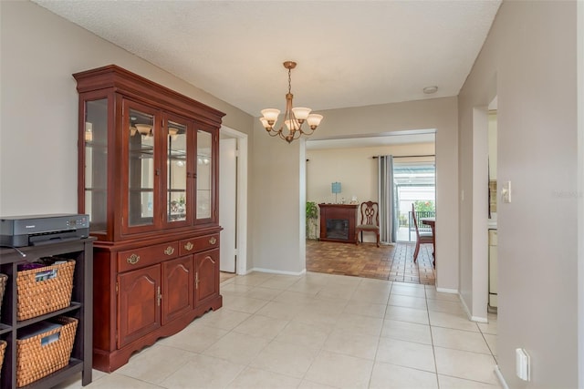 tiled dining room featuring a chandelier and a textured ceiling