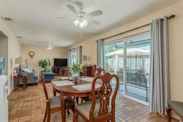 dining space with a textured ceiling and ceiling fan