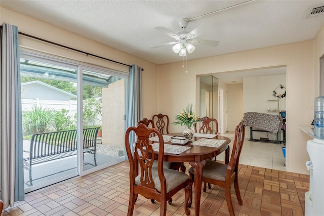 dining area with a textured ceiling and ceiling fan