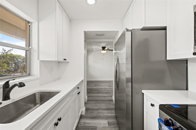 kitchen with white cabinets, sink, ceiling fan, stainless steel fridge, and dark hardwood / wood-style flooring