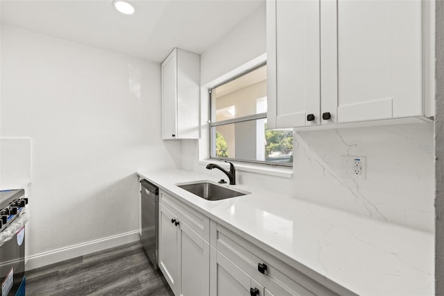 kitchen with light stone countertops, appliances with stainless steel finishes, white cabinetry, and sink