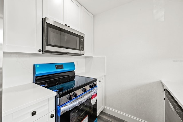 kitchen featuring white cabinets, hardwood / wood-style flooring, and appliances with stainless steel finishes