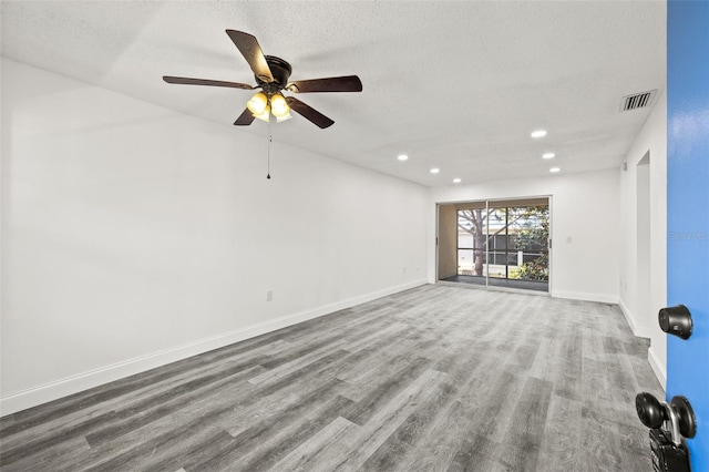 unfurnished room featuring hardwood / wood-style flooring, ceiling fan, and a textured ceiling