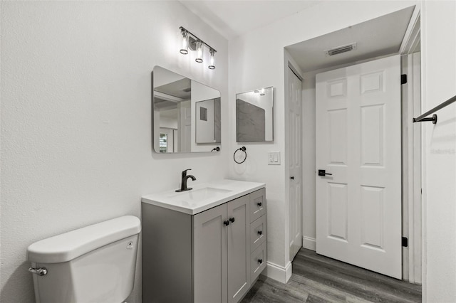 bathroom featuring wood-type flooring, vanity, and toilet