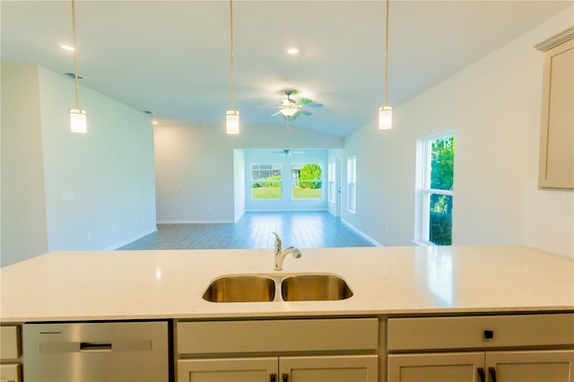 kitchen featuring light stone counters, ceiling fan, sink, dishwasher, and lofted ceiling