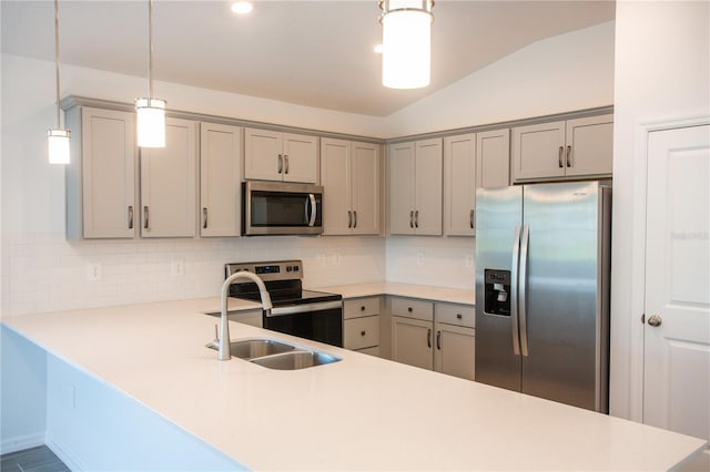 kitchen with kitchen peninsula, appliances with stainless steel finishes, decorative backsplash, hanging light fixtures, and lofted ceiling