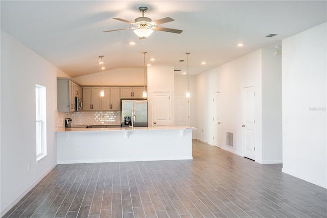 kitchen featuring vaulted ceiling, pendant lighting, dark hardwood / wood-style floors, and appliances with stainless steel finishes