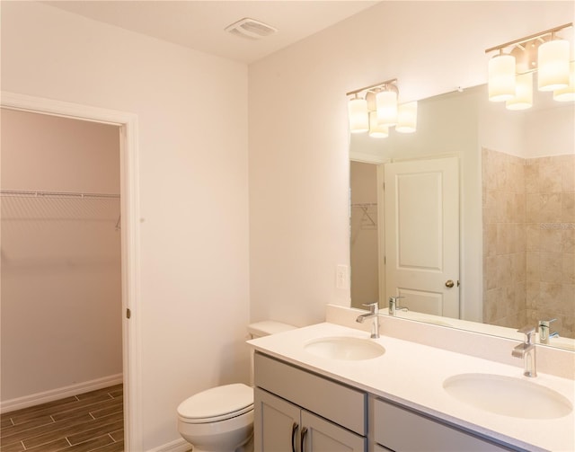25434 Colon Dr, Punta Gorda, FL 33983 - full bath with double vanity, toilet, a spacious closet, wood tiled floors, and baseboards