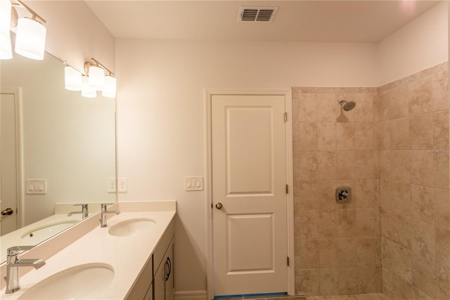 bathroom featuring a tile shower and vanity