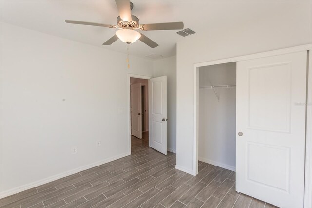 unfurnished bedroom with hardwood / wood-style flooring, ceiling fan, and a closet