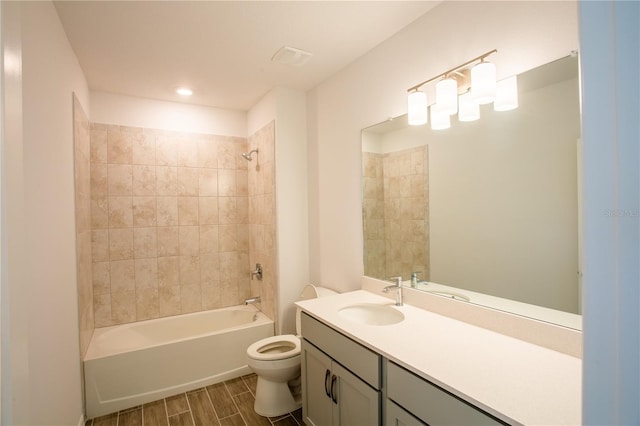 full bathroom featuring tiled shower / bath combo, toilet, and vanity