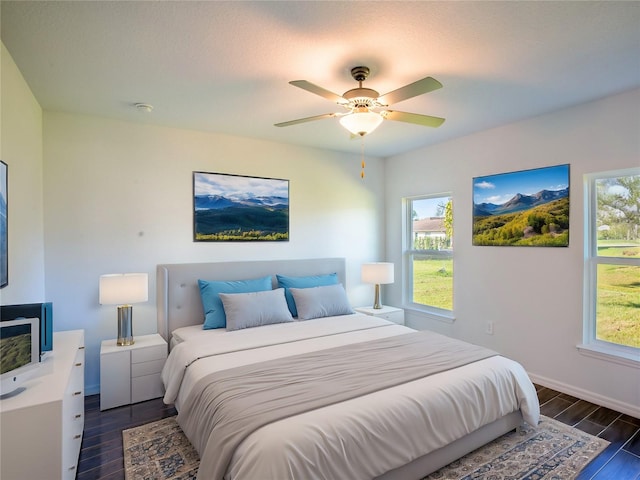 bedroom featuring multiple windows, ceiling fan, and dark wood-type flooring