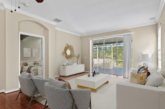 living room with ceiling fan, wood-type flooring, and crown molding