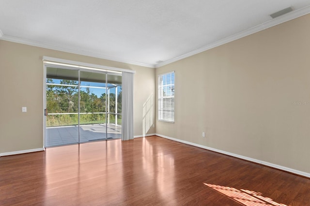 empty room with hardwood / wood-style floors and ornamental molding