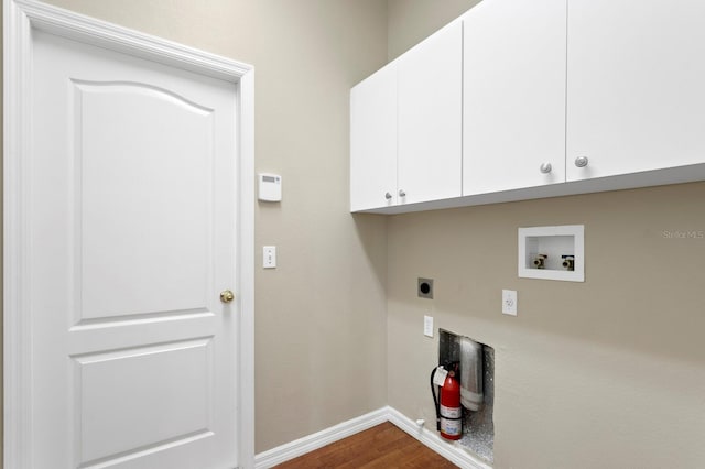 laundry area featuring washer hookup, electric dryer hookup, cabinets, and wood-type flooring