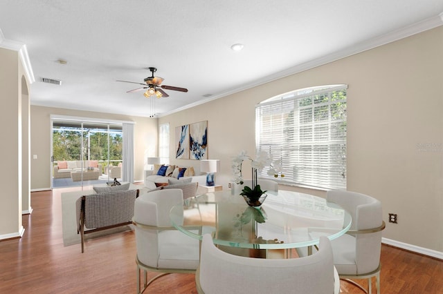 dining space featuring hardwood / wood-style floors, ceiling fan, and crown molding