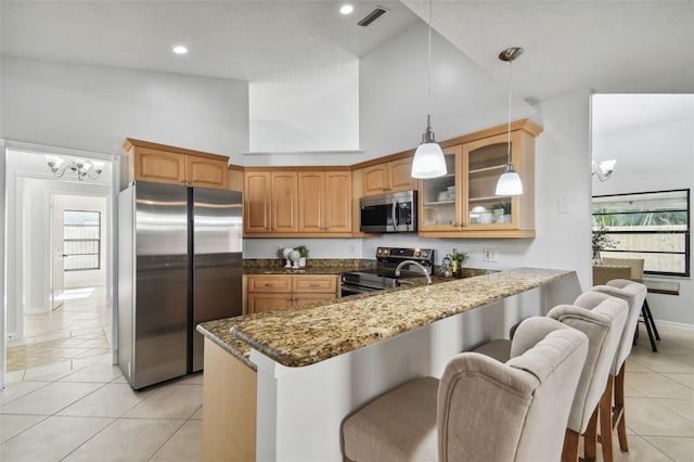 kitchen with kitchen peninsula, appliances with stainless steel finishes, high vaulted ceiling, and a healthy amount of sunlight