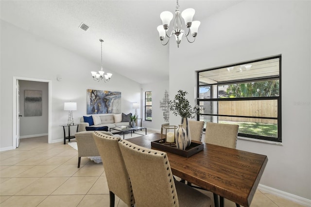 dining space featuring a notable chandelier, light tile patterned floors, a textured ceiling, and high vaulted ceiling