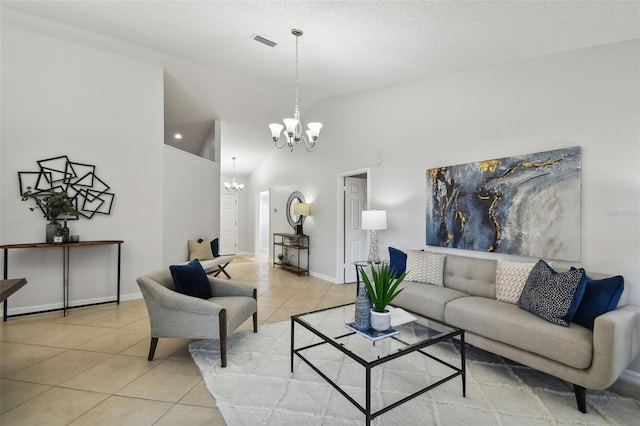 living room with a textured ceiling, high vaulted ceiling, light tile patterned floors, and a notable chandelier