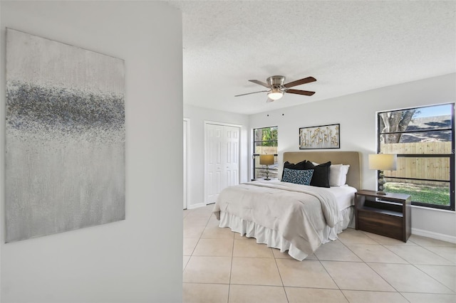 tiled bedroom featuring a textured ceiling, a closet, and ceiling fan