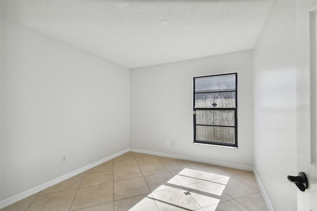 tiled spare room with a textured ceiling