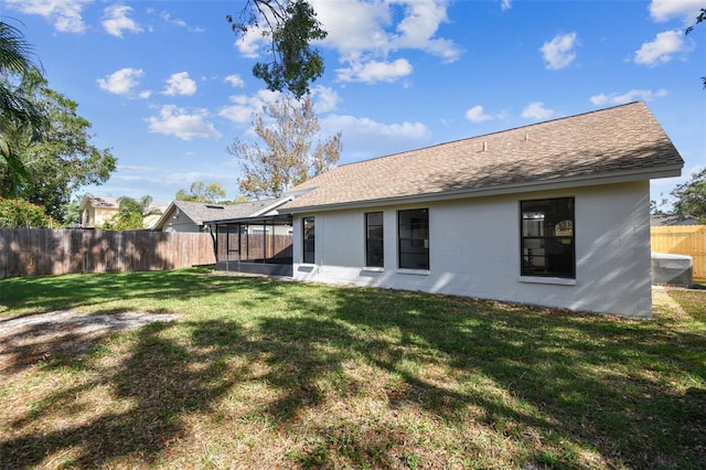 rear view of house featuring a sunroom and a yard