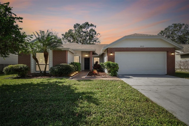 single story home with a garage and a yard