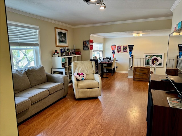 living room featuring a healthy amount of sunlight, light wood-type flooring, and ornamental molding