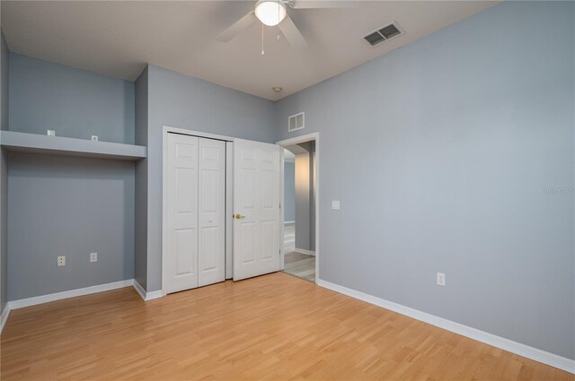 unfurnished bedroom featuring ceiling fan, a closet, and light hardwood / wood-style flooring