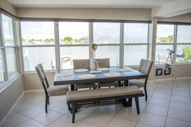 tiled dining space with a water view and a wealth of natural light