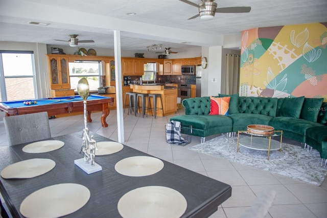 interior space featuring ceiling fan, beamed ceiling, light tile patterned floors, and billiards