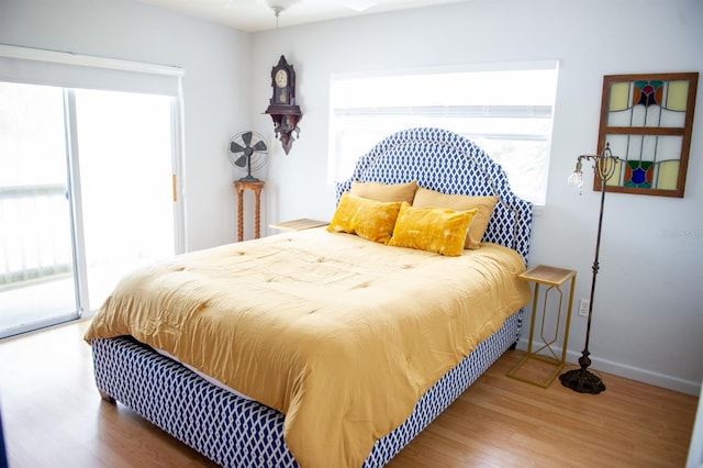 bedroom featuring wood-type flooring and access to outside