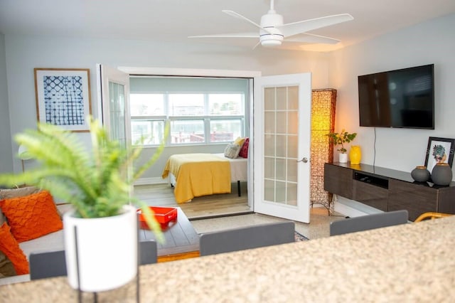 living room with french doors, ceiling fan, and wood-type flooring