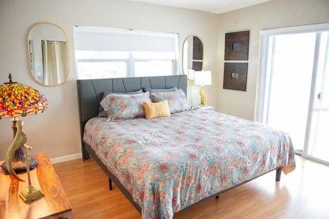 bedroom with multiple windows and light hardwood / wood-style flooring