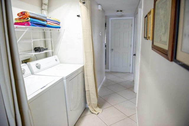 laundry room featuring separate washer and dryer and light tile patterned flooring