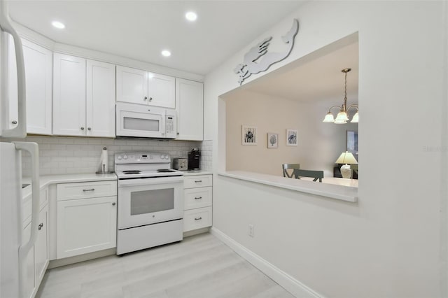 kitchen featuring a notable chandelier, white cabinetry, white appliances, and backsplash