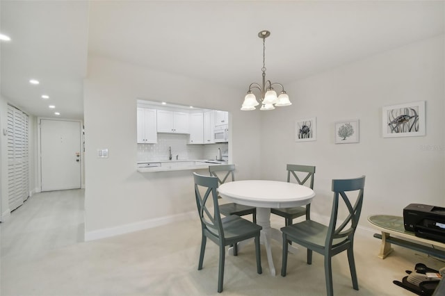 dining space featuring sink and an inviting chandelier