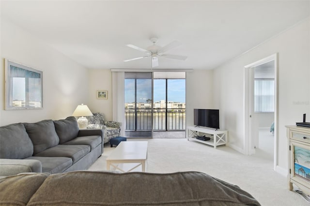 living room featuring ceiling fan, light colored carpet, and a wealth of natural light