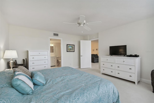 bedroom featuring connected bathroom, light colored carpet, and ceiling fan