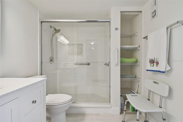 bathroom featuring vanity, toilet, and a shower with shower door