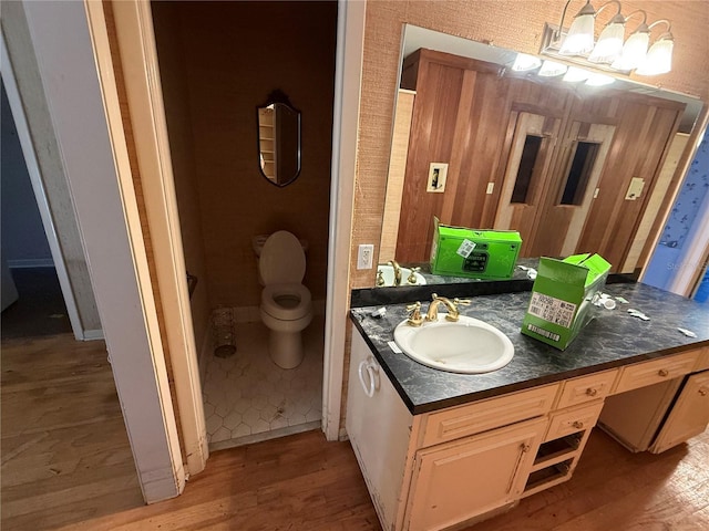 bathroom with hardwood / wood-style floors, vanity, and toilet