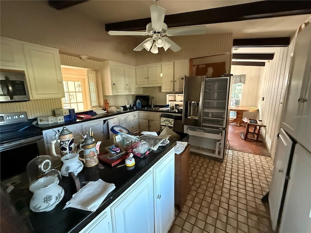 kitchen with ceiling fan, beam ceiling, white cabinetry, and stainless steel appliances