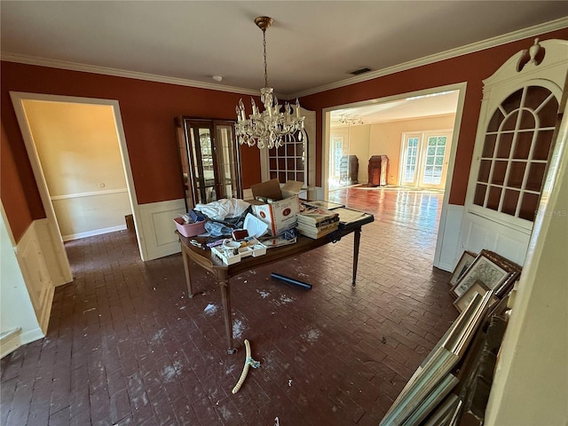 unfurnished dining area with ornamental molding and a chandelier