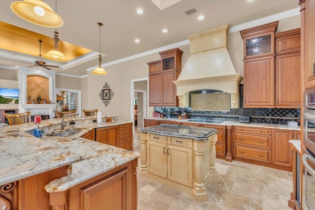 kitchen featuring pendant lighting, ceiling fan, a large island, and custom exhaust hood