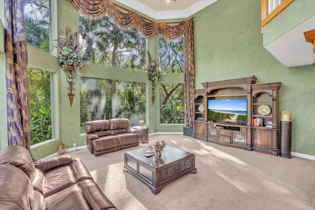 living room with carpet flooring, a wealth of natural light, and a high ceiling