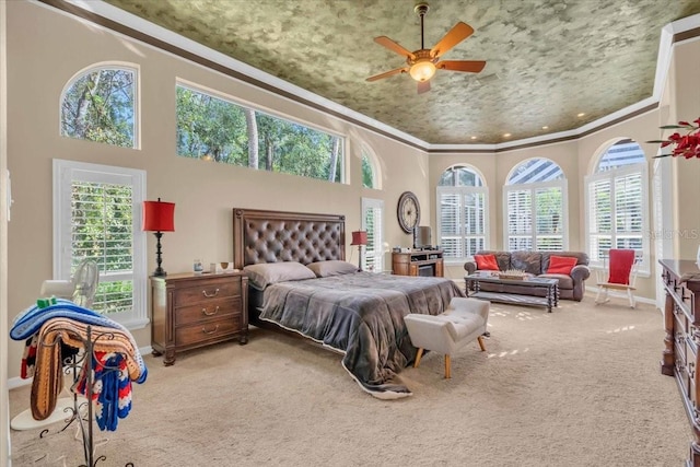 bedroom featuring ceiling fan, light carpet, a high ceiling, and ornamental molding