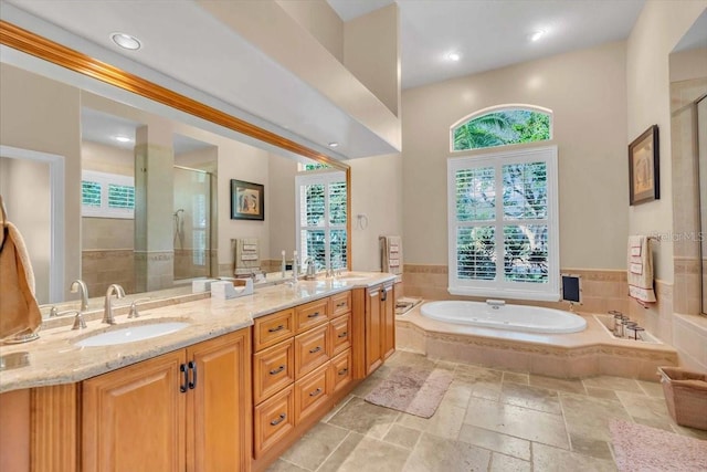 bathroom with vanity and shower with separate bathtub